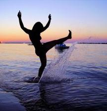 silhouette of girl splashing water at sunset