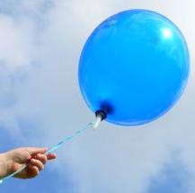 hand releasing blue balloon