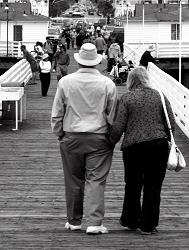 man and woman walking on pier