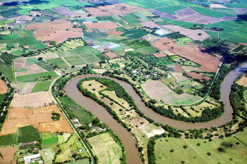 river flowing through farmland aerial shot