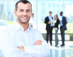 cross-armed leader looking at camera in working environment