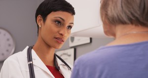 Young Intelligent Female Doctor Talking To Elderly Patient