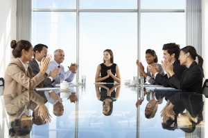 Group Of Business People Having Board Meeting Around Glass Table