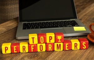 Top Performers written on a wooden cube in a office desk